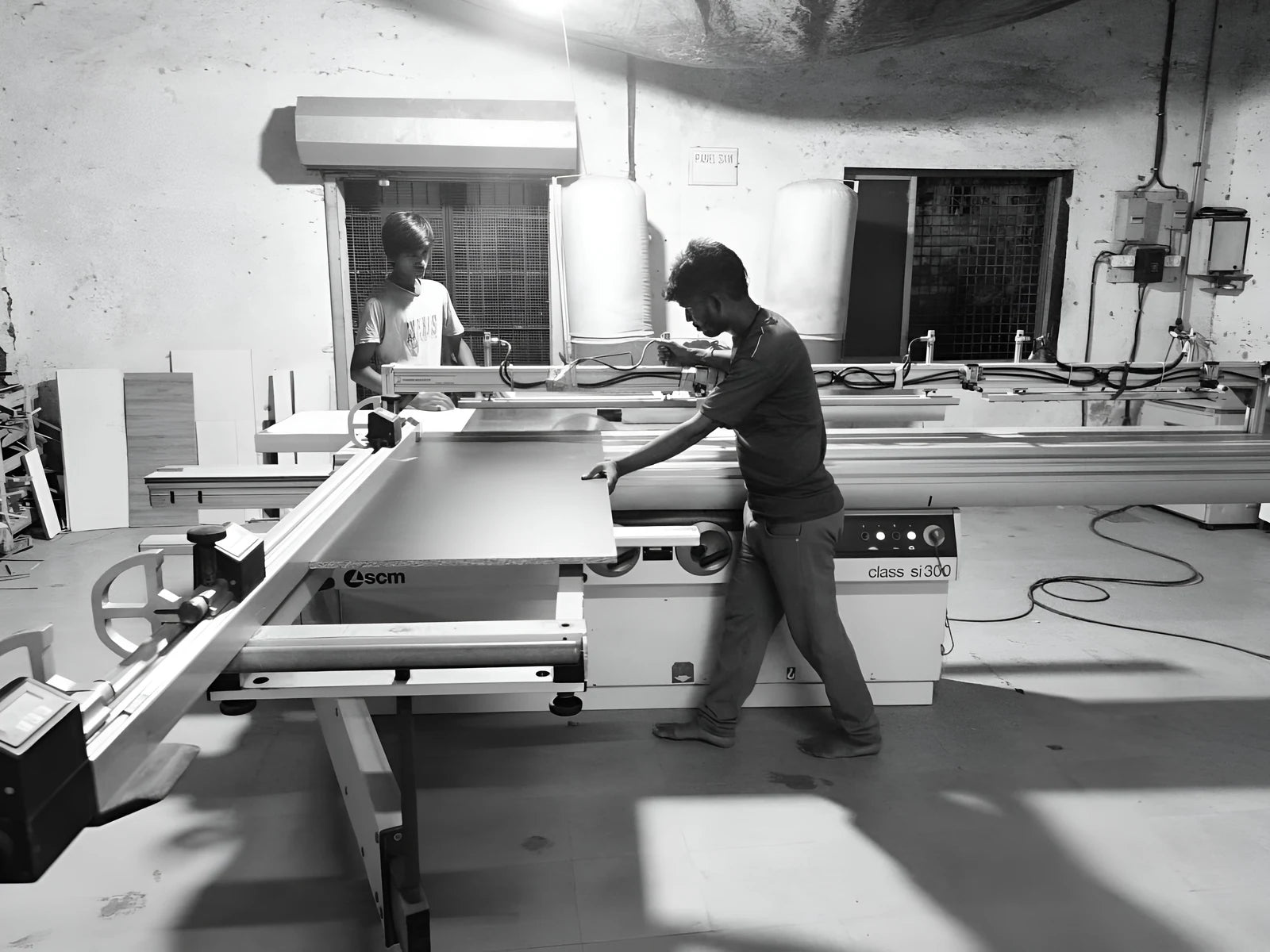 Two of the Furniva workshop team cutting a panel to size on the sliding saw in Jaipur